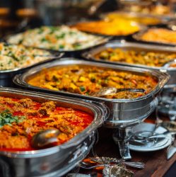 Traditional indian buffet table with assorted curry dishes, fragrant basmati rice, fresh vegetable specialties and authentic regional cuisine served in stainless steel catering containers, vibrant foo